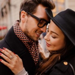 romantic-couple-face-face-hugging-smiling-warm-cozy-colors-winter-mood-handsome-man-elegant-dark-haired-woman-walking-city_273443-4195